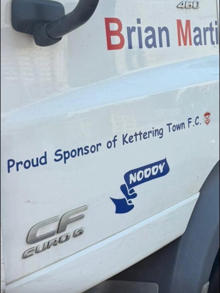 KTFC_BM_Pallets_SIgn | Kettering Town FC Side of a white van with red and blue text reading 'Brian Martin' and the slogan 'Proud Sponsor of Kettering Town F.C.' plus a blue 'NODDY' logo graphic and vehicle badges visible.
