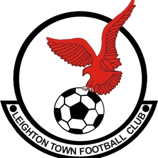 Emblem of Leighton Town Football Club: a red bird perched on a soccer ball inside a circle, with the club name on a banner.